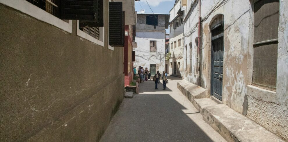 a narrow street with people walking down it