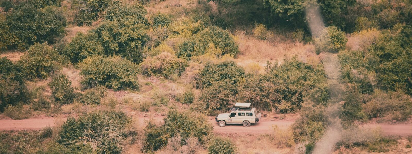 a van is parked in the middle of a dirt road